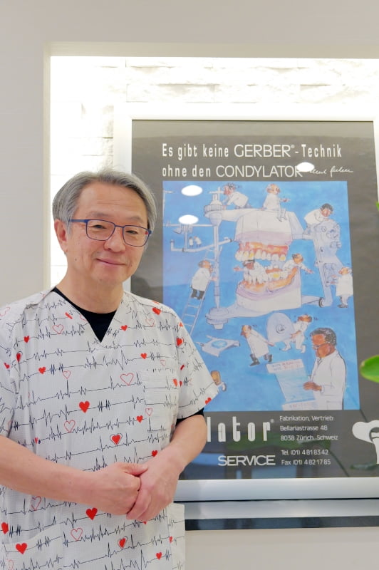 桐山立志院長が手を前に組んで立っている